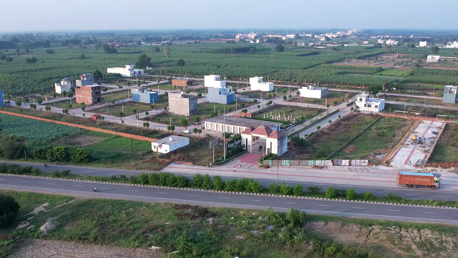 Wide aerial of Defence Garden Phase 2: its streets, plots and first homes between the main road and the fields