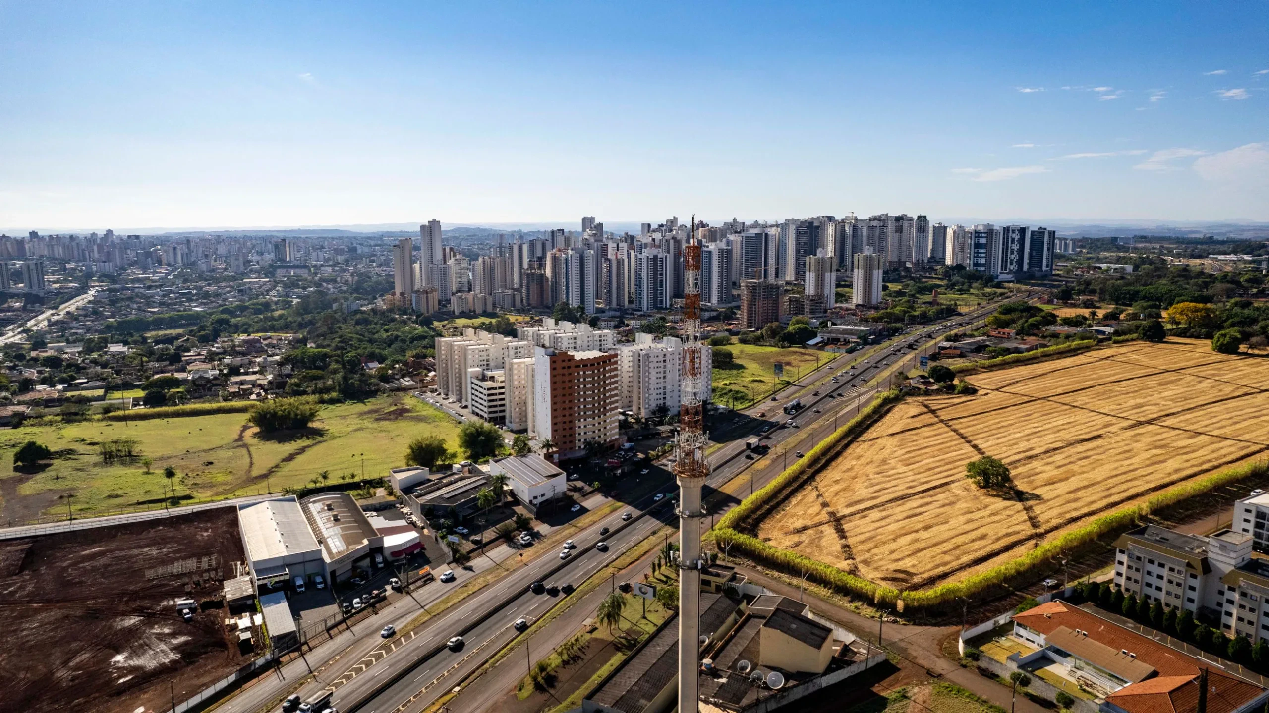 Open green fields meeting a city skyline