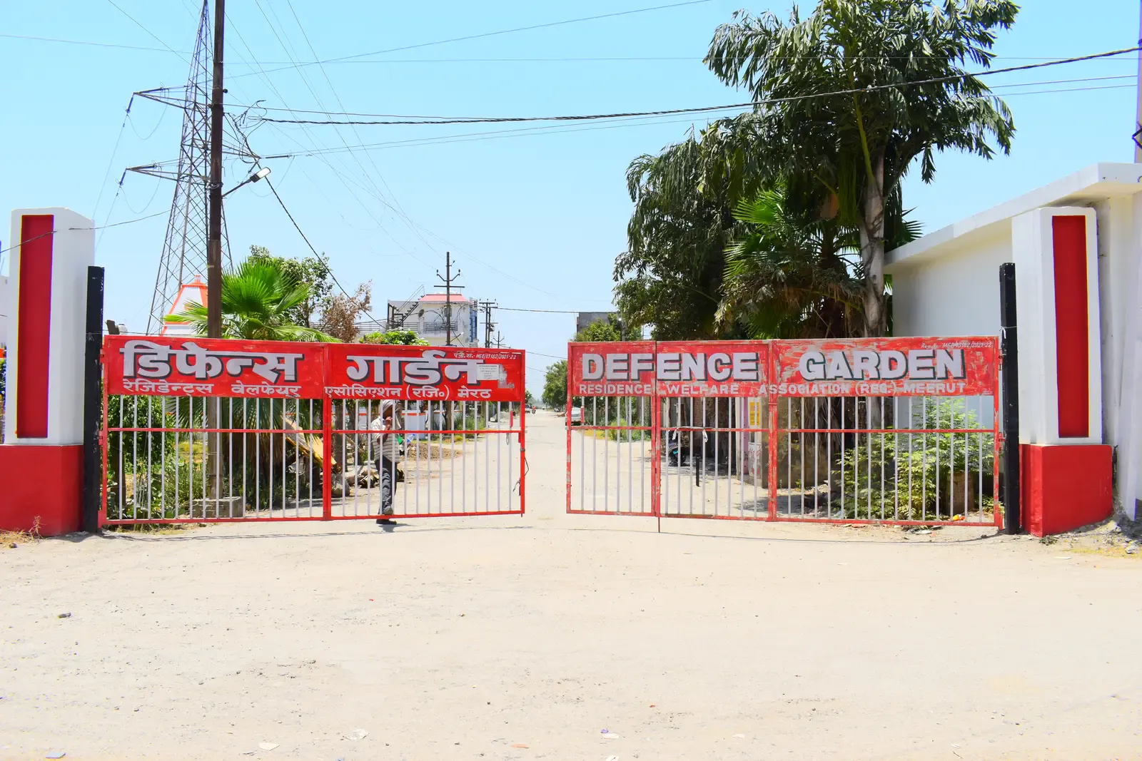 Defence Garden Meerut entrance with red gates and bilingual Defence Garden signage