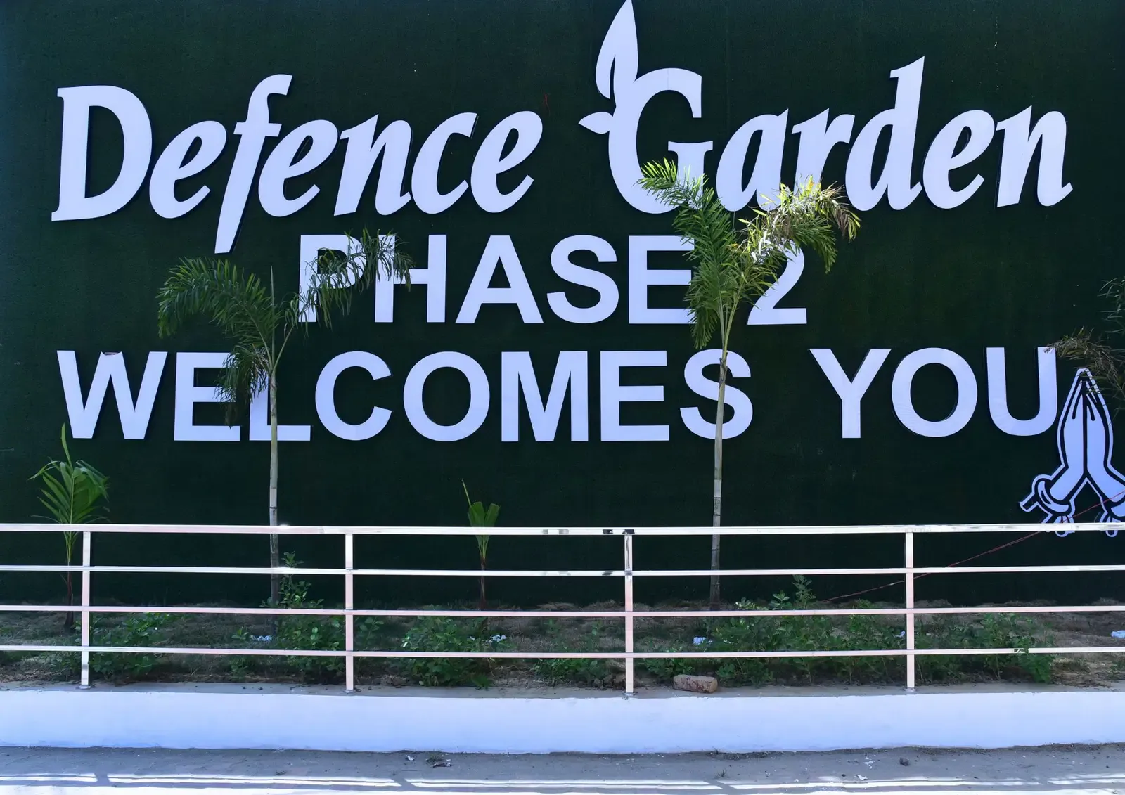 Green signage wall reading "Defence Garden Phase 2 Welcomes You"