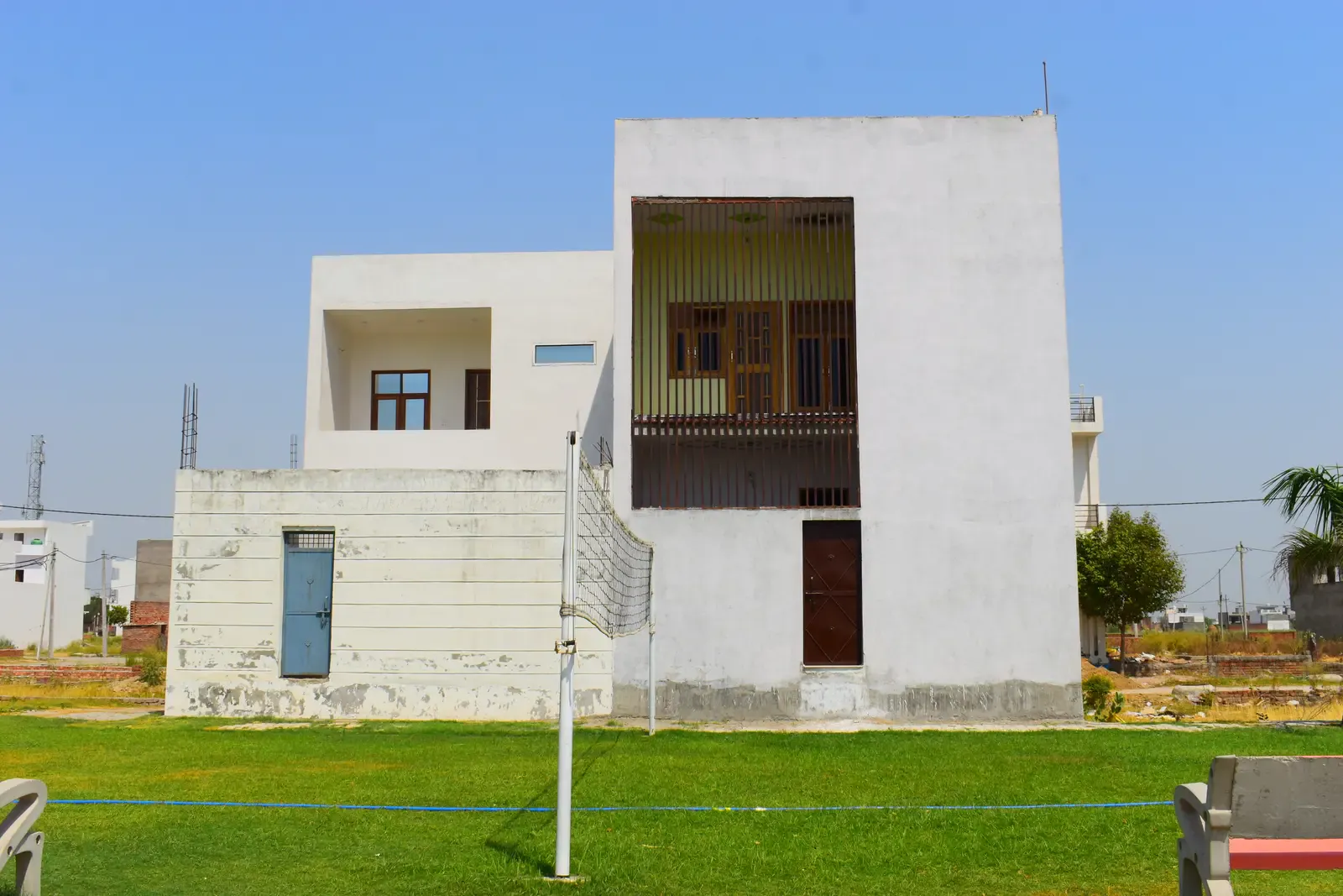 Basant Kunj: modern white house beside a railed green park