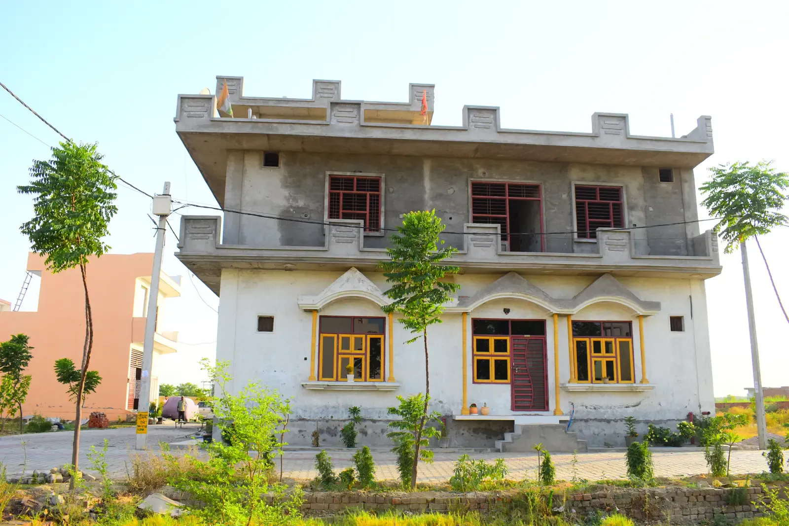 Gayatri Enclave: two-storey house with yellow window frames awaiting its final finish