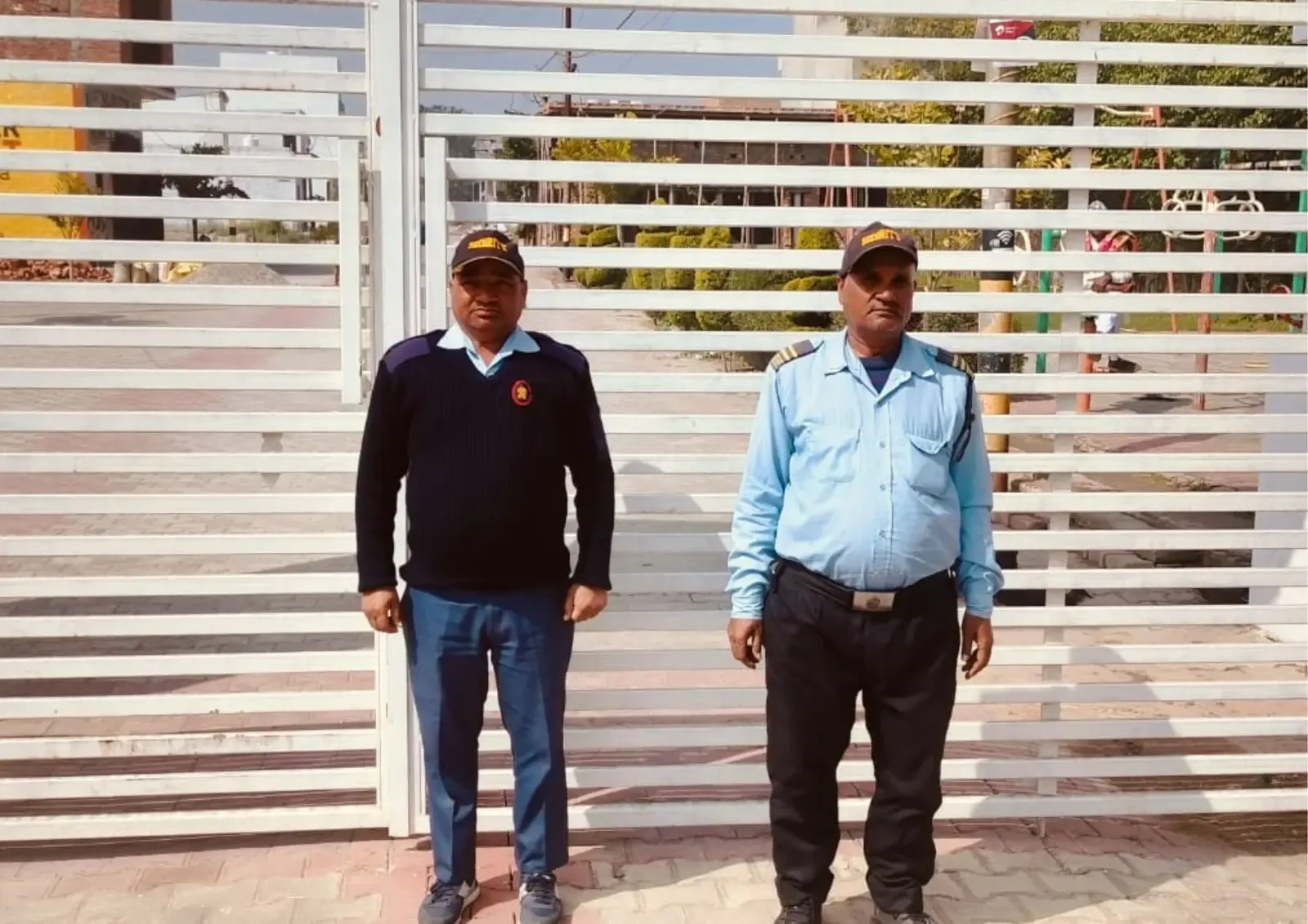 Two uniformed security guards standing at the Defence Garden Phase 1 gate