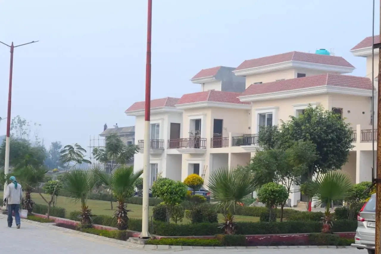 Ganpati Enclave: corner villas with red-tiled roofs above a landscaped garden
