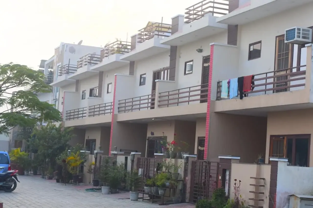 Ganpati Enclave: terrace of townhouses with balconies along a paved lane