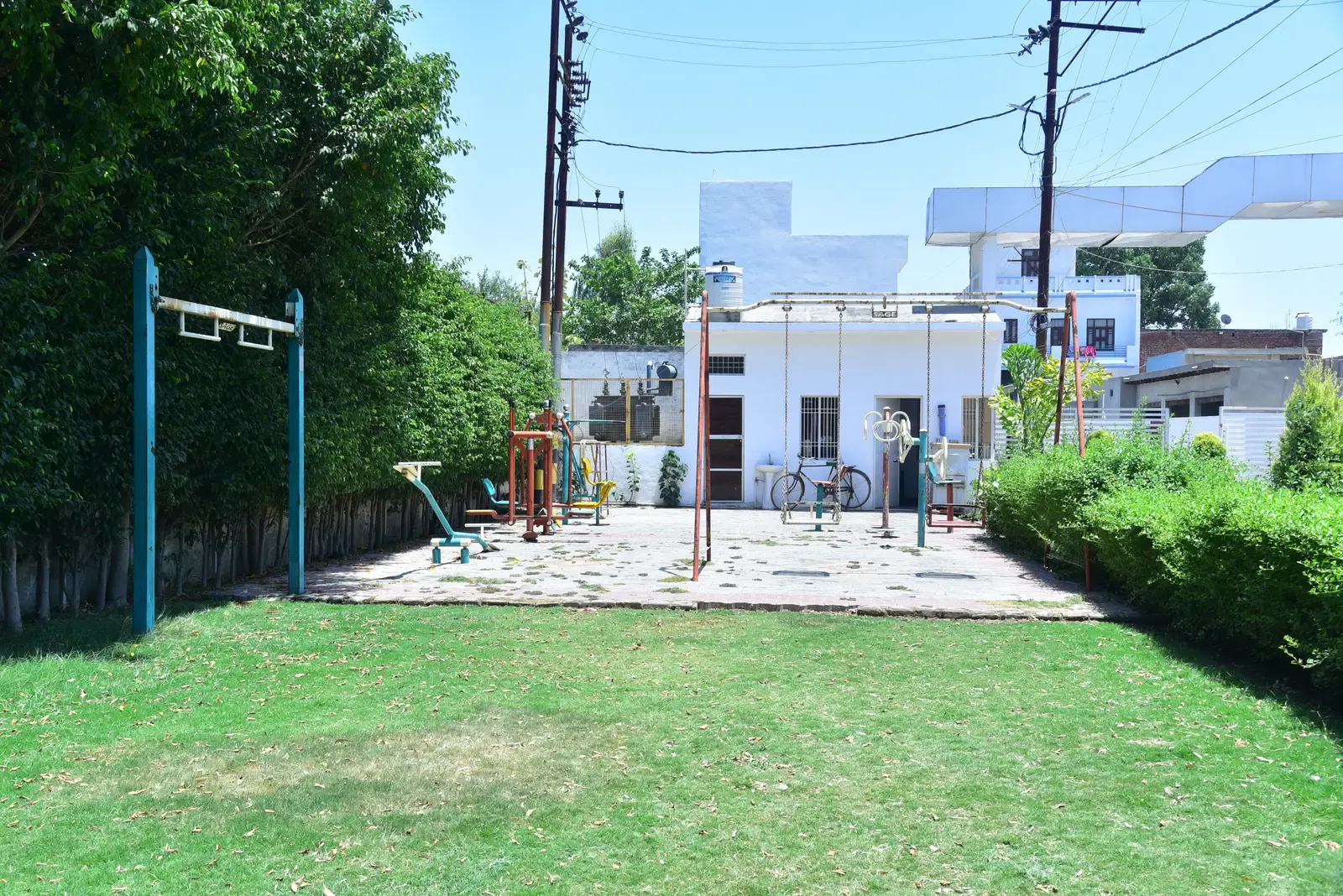 Defence Garden Phase 1 park with outdoor gym equipment and swings on a green lawn