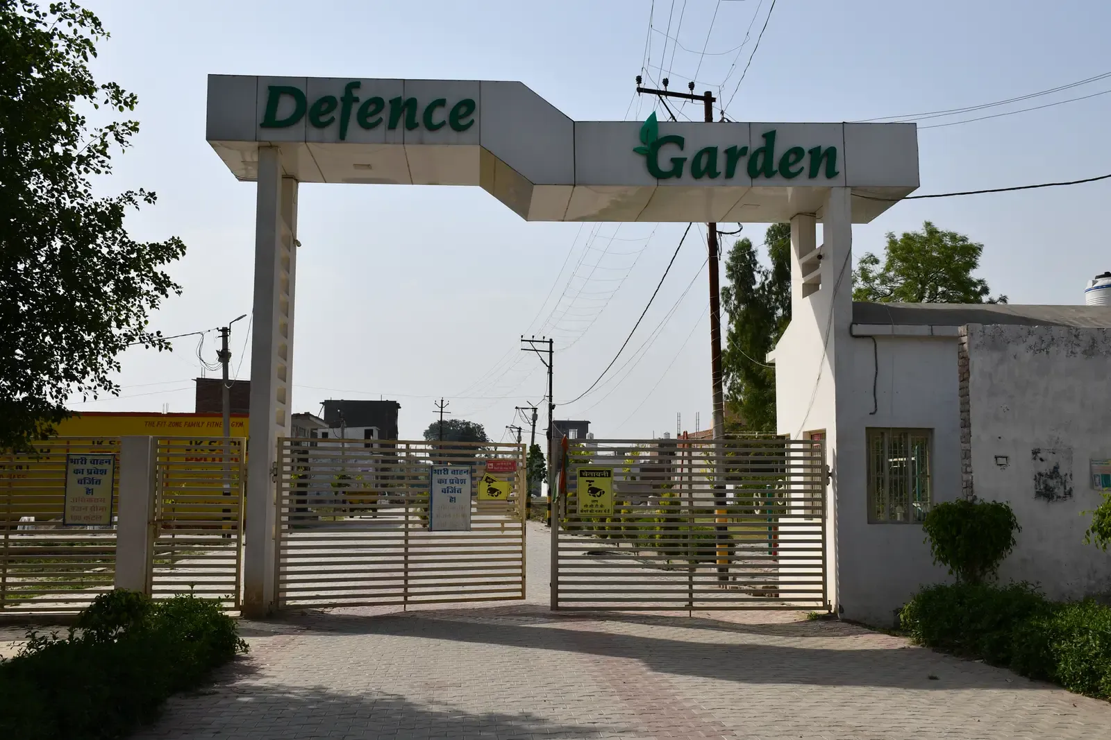 Defence Garden Phase 1 entrance arch with green lettering and sliding gates