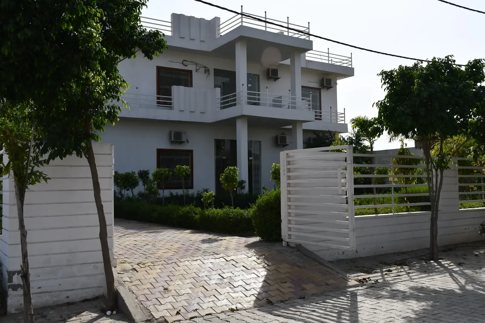 Defence Garden Phase 1: white villa with balconies behind a slatted boundary fence and paved driveway