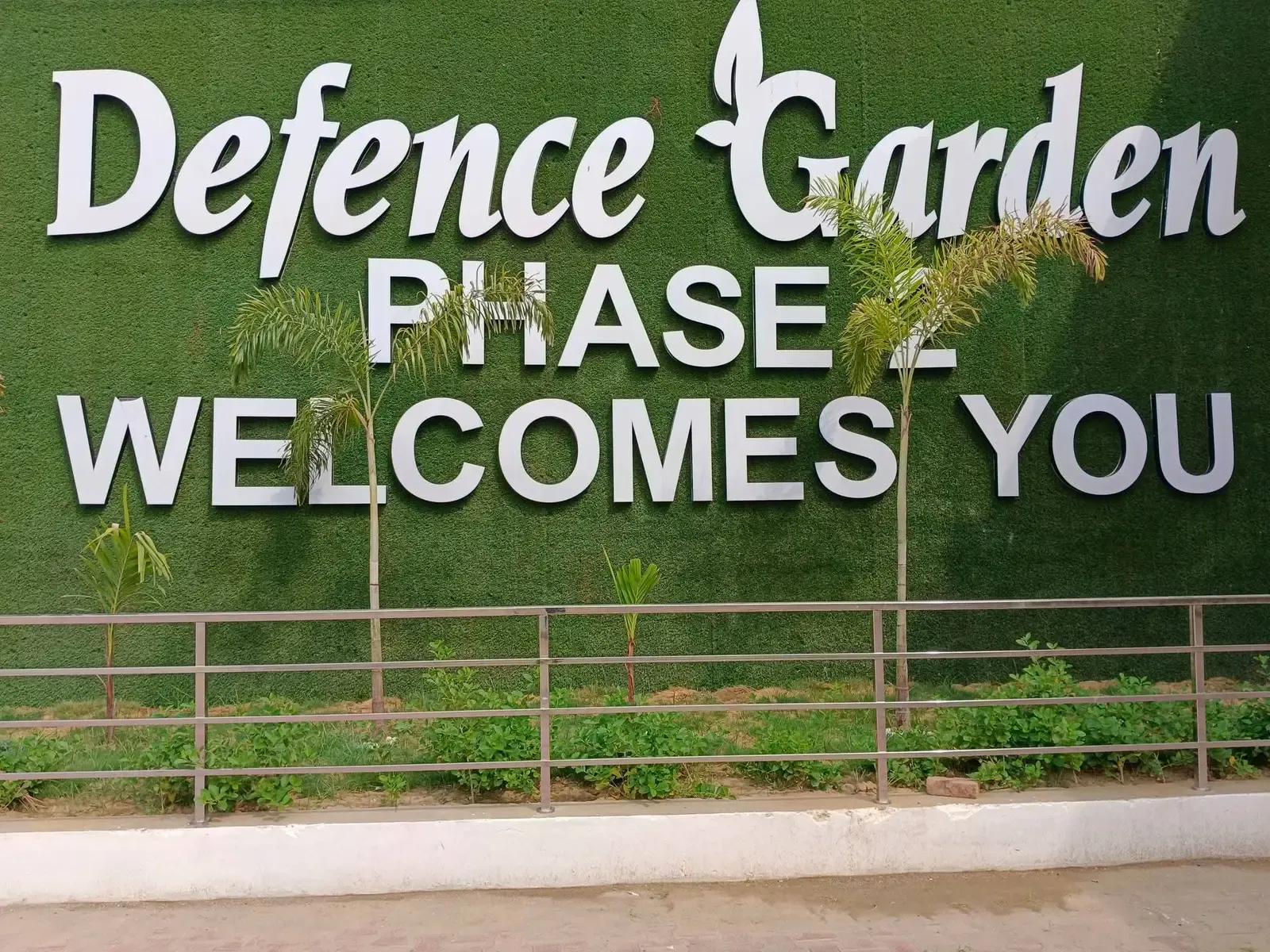 Green signage wall reading "Defence Garden Phase 2 Welcomes You"