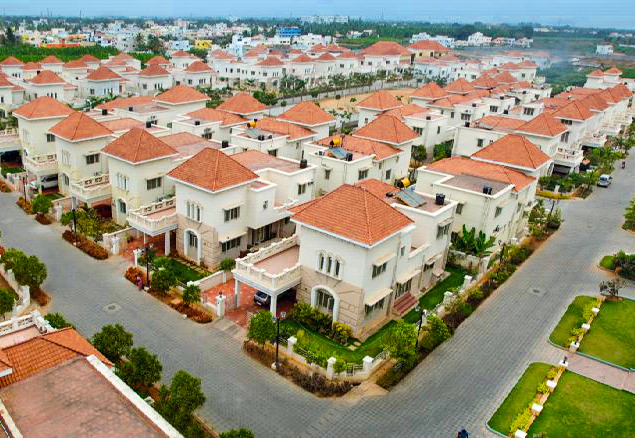 Aerial photograph of independent cream villas, red-tiled roofs and connected streets at Sakthi Garden in Coimbatore