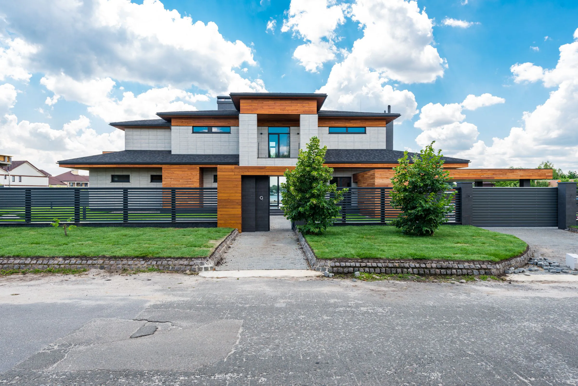 Contemporary villa with a clear entrance path, boundary fence and geometric frontage
