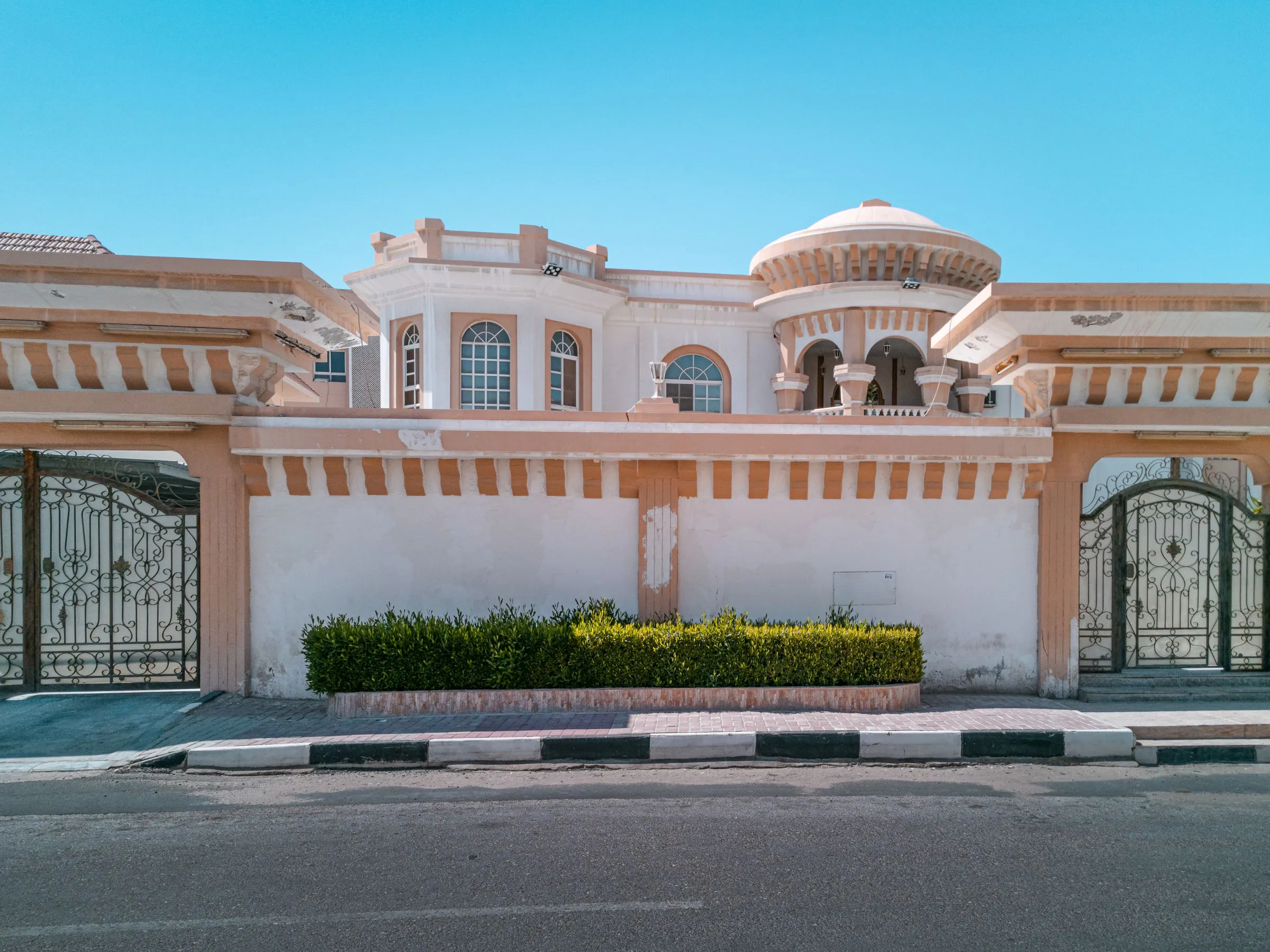 Elegant residence with a gated entrance, decorative facade and boundary wall