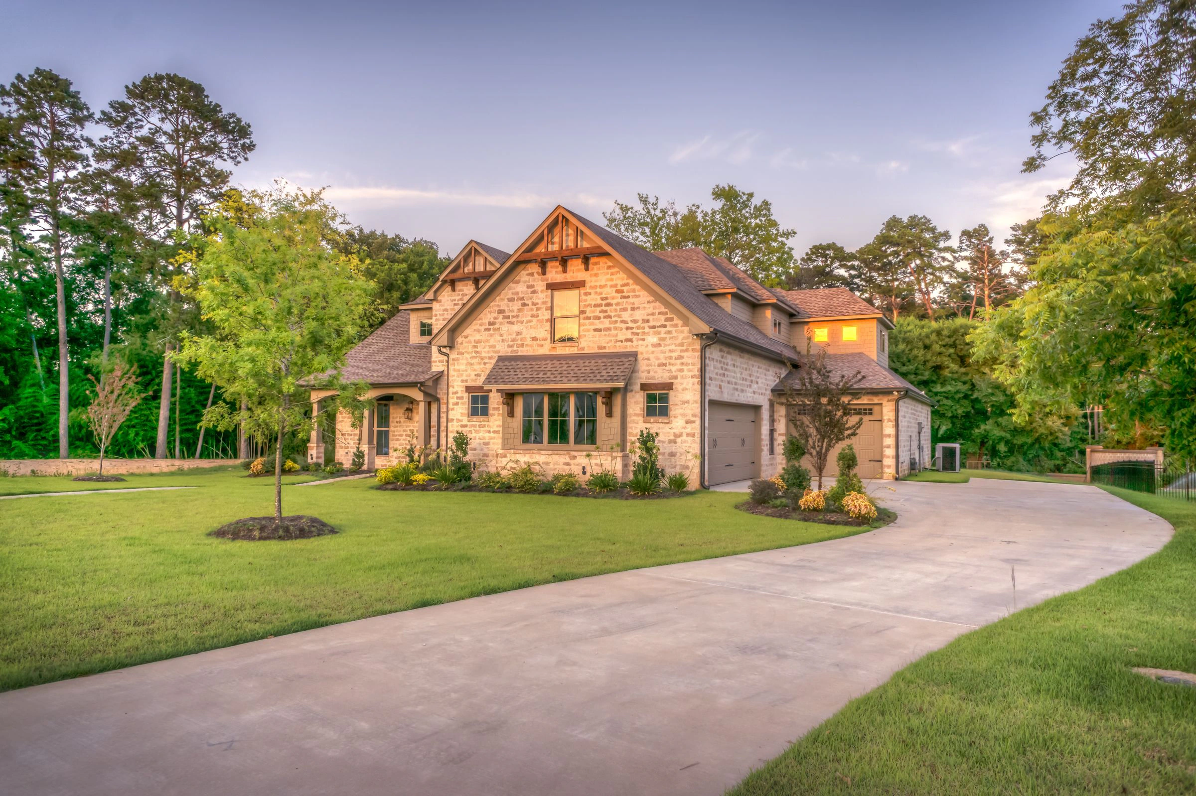 Country home framed by mature trees and expansive green lawns
