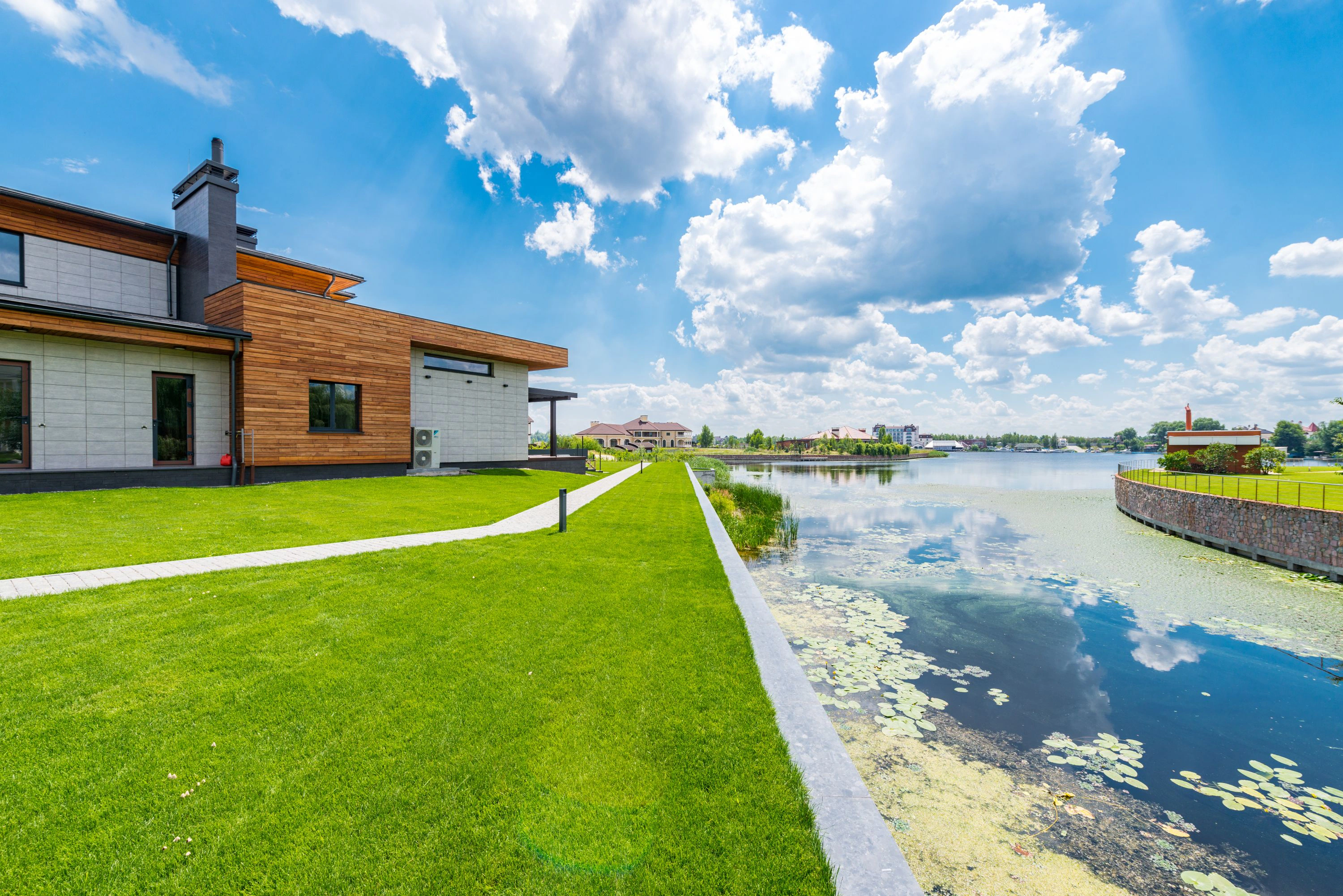 Modern home beside lawns and a lake